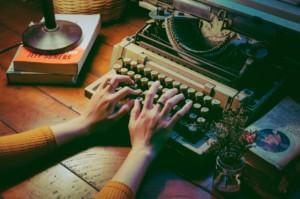 Kädet kirjoituskoneella kirjoittavat eri tarinatyyppejä.